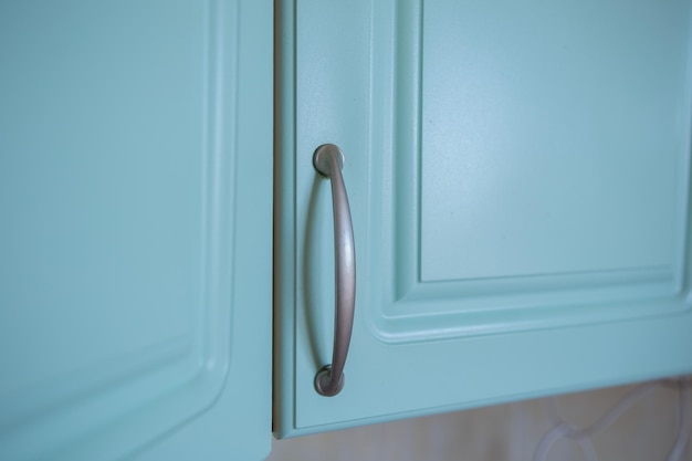 A metal shelf handles in a blue kitchen