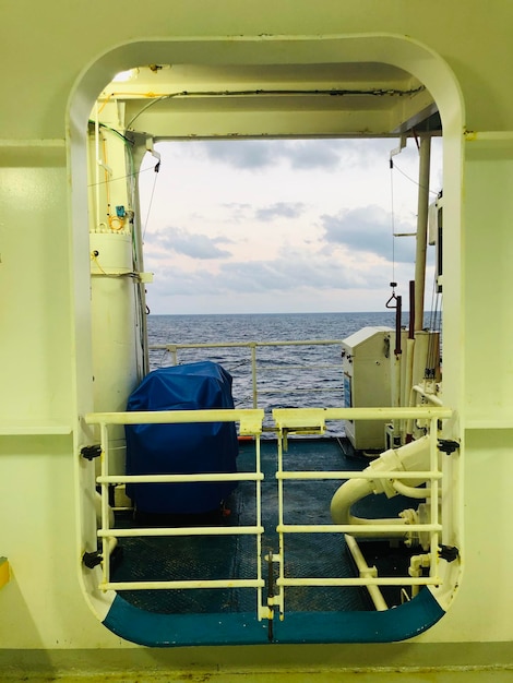 Foto nave di metallo in mare contro il cielo visto attraverso la finestra