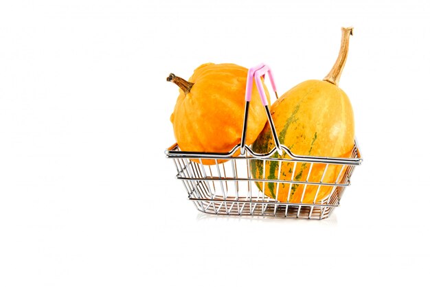 Metal shopping basket with pumpkins isolated on white.