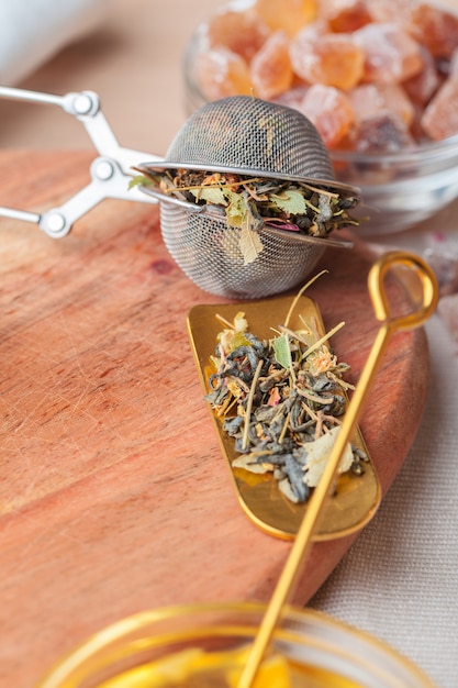 Metal sieve with dried  herbal tea in a glass cup