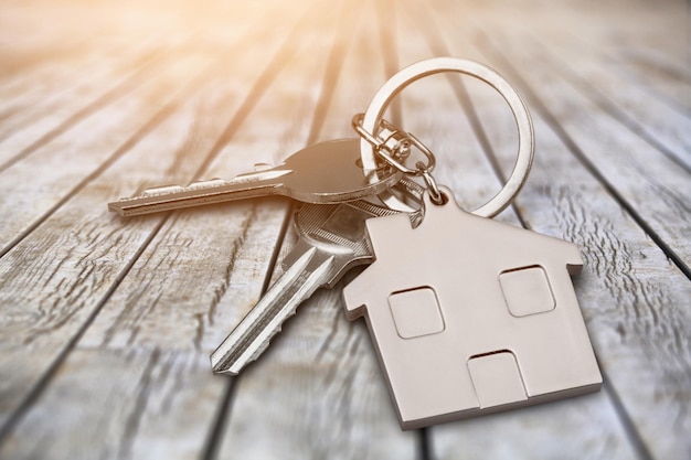 Metal silver house keys with house figure on desk