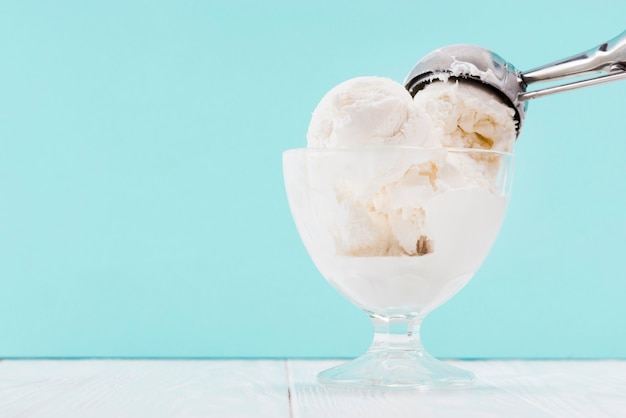 Cucchiaio di metallo in tazza di gelato alla vaniglia