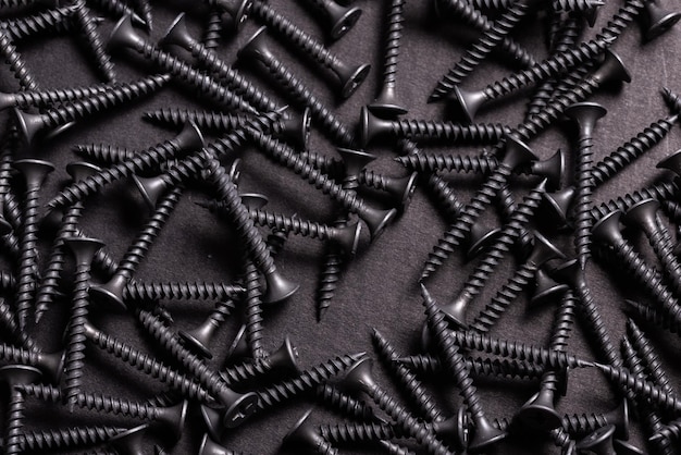 Photo metal stainless steel self tapping screws on black wooden background