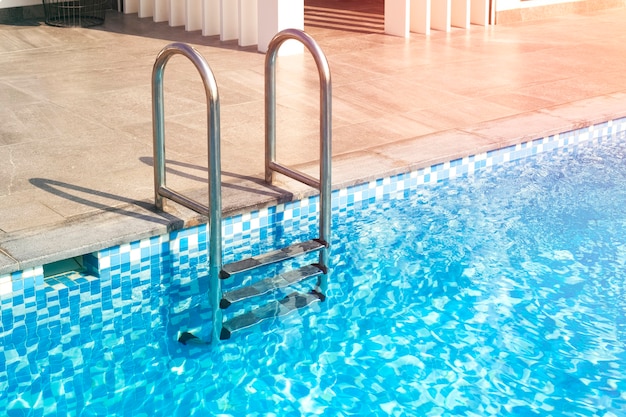 Metal staircase leads to the pool Blue water in the pool of a large house