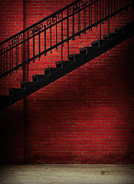 Metal stairway with grunge red brick wall background