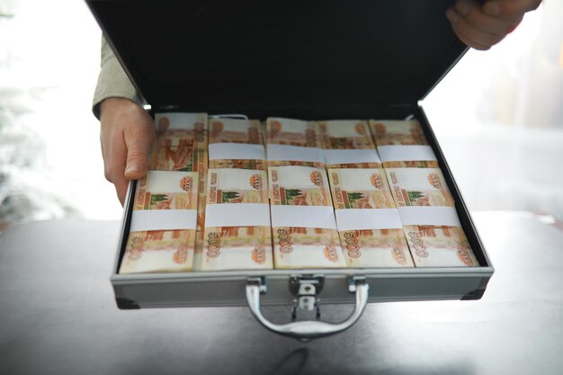 Металлический чемодан с российскими банкнотами 5000 рублей. Инвестиции, взятки, концепция коррупции.