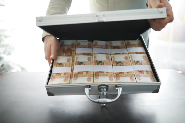 Металлический чемодан, наполненный российскими банкнотами в 5000 рублей Концепция коррупции в отношении инвестиций