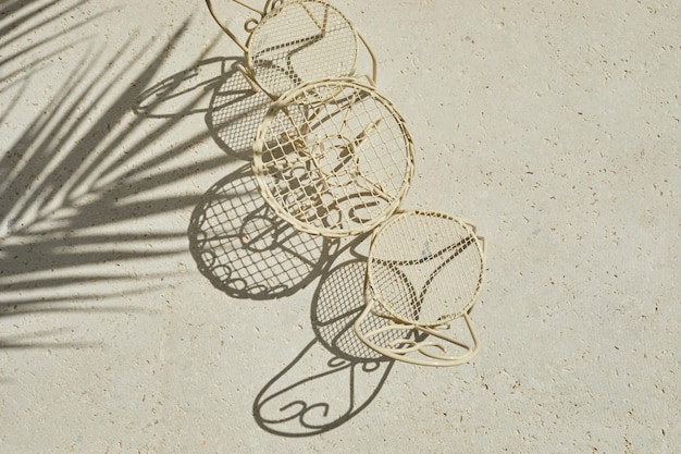 Metal table and chair on travertine stone background minimal layout with sunshine and hard shadow pa