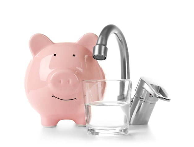 Metal tap and pig money box isolated on white. Water saving concept