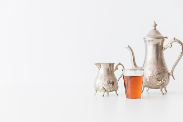 Metal tea set and glass of tea