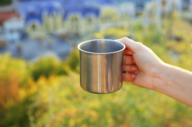 Photo metal touristic tea cup in female hands