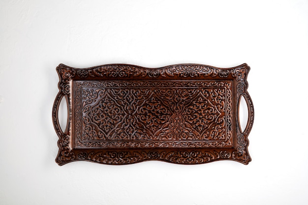 Metal tray with an oriental ornament on light background Top view copy space