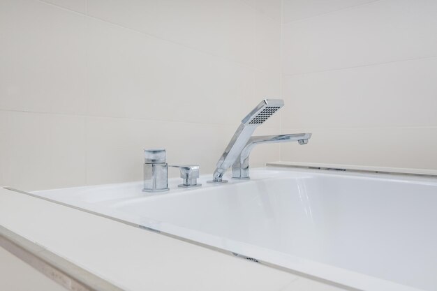 Metal water tap with sink and faucet to turn on and regulate cold or hot water in expensive bathroom