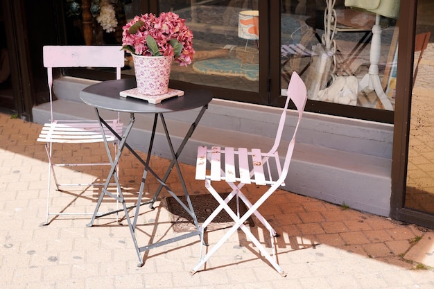 Metal wooden pink chair seat table in summer street in city