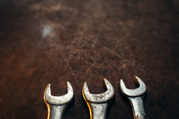 Metal wrenches on rusty old desk