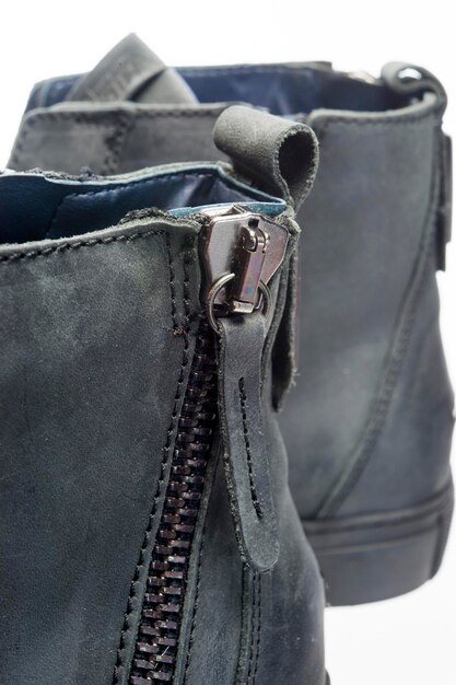 レザーブーツの靴のクローズアップショットに舌が付いた金属製のジッパー