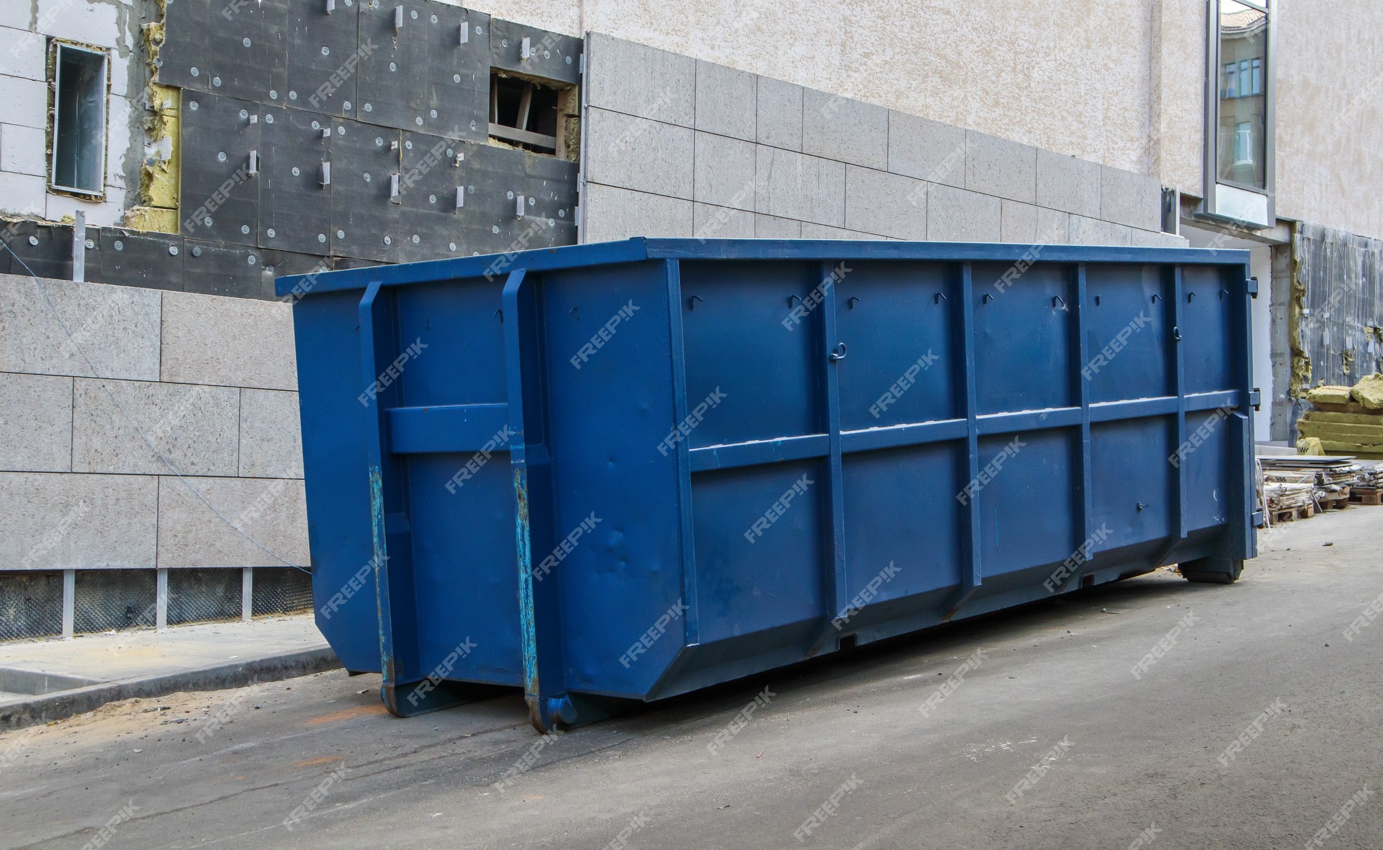 Metalen duurzame industriële vuilnisbak voor buitenafval de bouwplaats. grote afvalmand voor huishoudelijk of industrieel afval. een stapel afval. Premium Foto