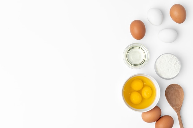 Metalen garde en eieren voor het koken op wit wordt geïsoleerd