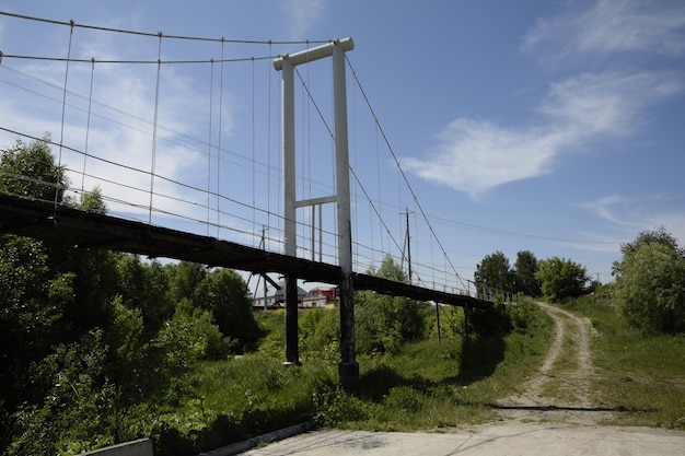 Metalen hangbrug over de rivier door dichte vegetatie Ulyanovsk Rusland