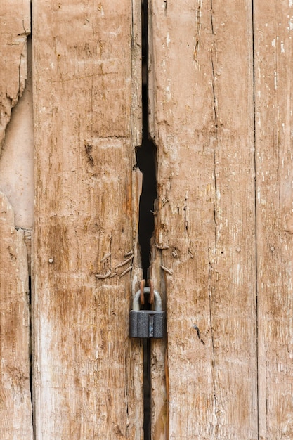 Metalen hangslot op een oude houten poort