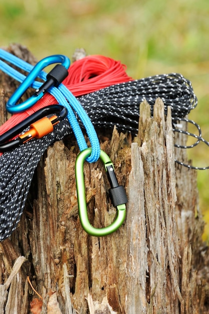 Metalen karabijn en touw voor bergbeklimmen Foto van gekleurde karabijnen en touw Klimconcept