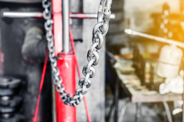 Foto metalen ketting op een rode lift in een autoreparatiewerkplaats