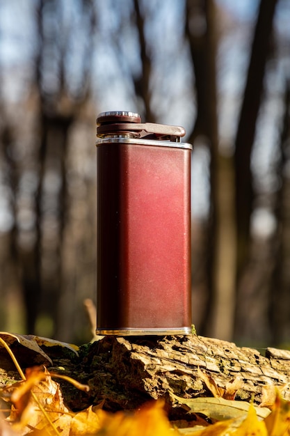 Metalen kolf voor alcohol in het herfstbos Herfstwandelingen Reisaccessoires voor heren