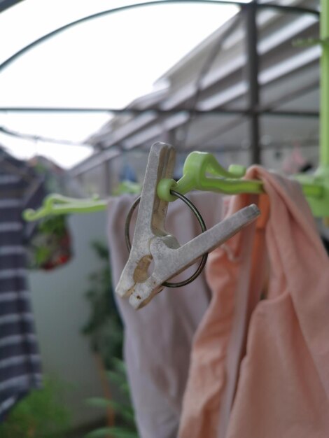 Metalen of plastic hangers en clips worden gebruikt om kleding buiten op de open veranda te drogen