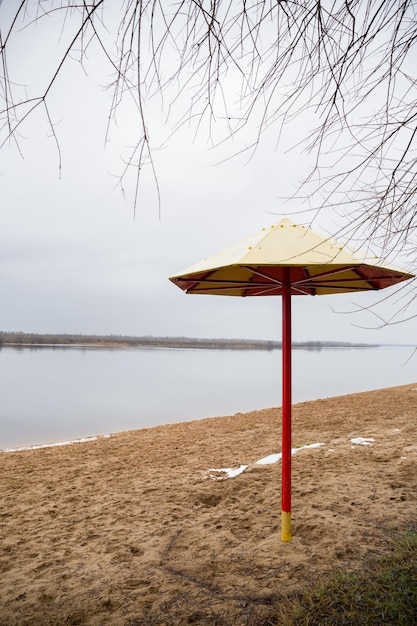 Metalen parasol op een leeg strand op een koude winterdag