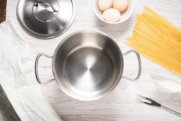 Metalen pot kookgerei, fornuis met pasta op keukentafel