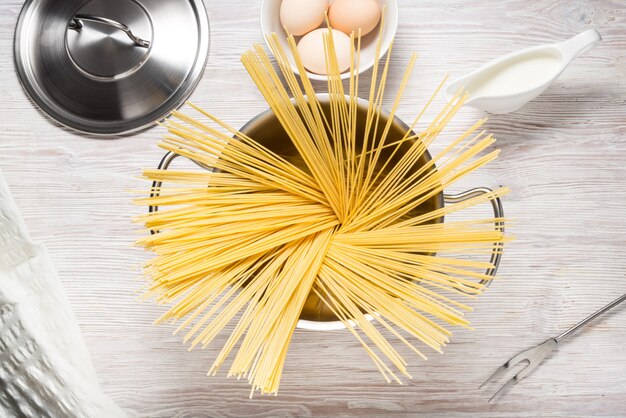 Metalen pot kookgerei, fornuis met pasta op keukentafel