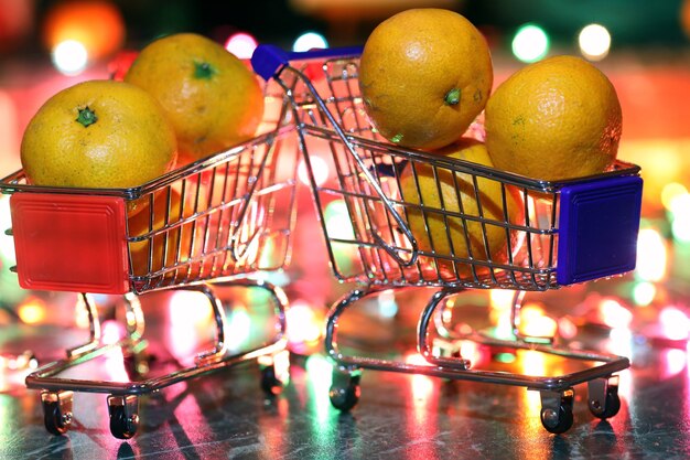 Metalen supermarktkarretje op een achtergrond van gekleurde lichten