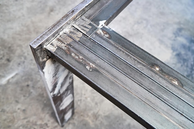 Metalen tafelonderstel gelast van metalen platen en rechthoekige buizen in de close-upweergave van de werkplaats