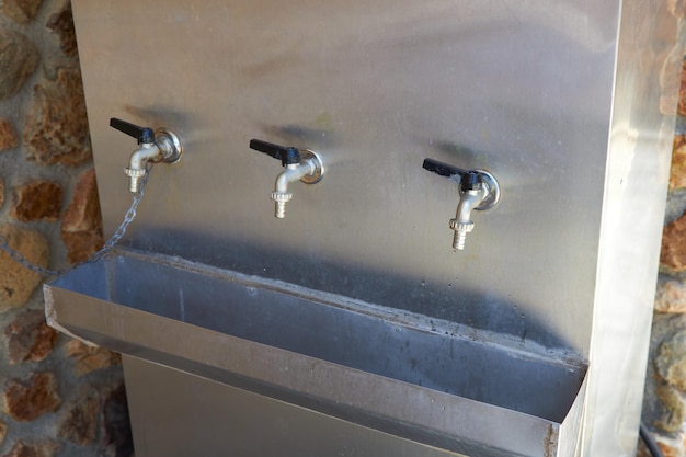 Foto metalen tank met drinkwater en drie kranen