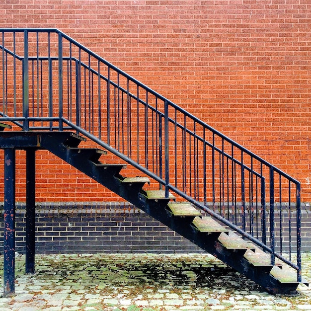 Metalen trap tegen een bakstenen muur