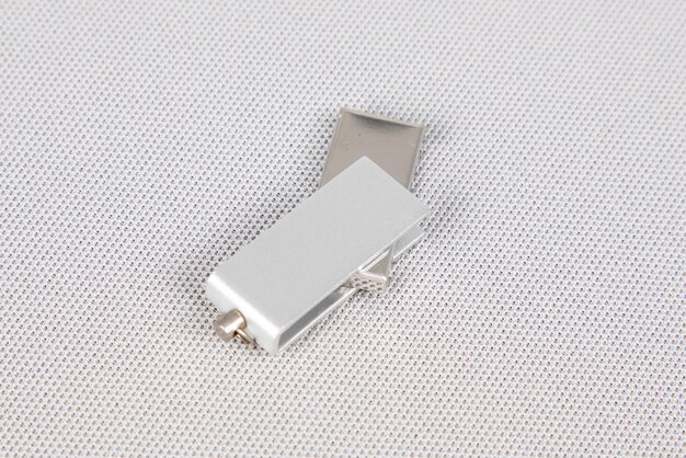 Metalen zilveren USB-flashdrive klaar om te worden aangesloten op een witte bureau grijze achtergrond