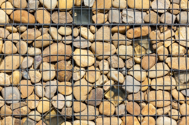 울타리로 자연석으로 채워진 금속 바구니 그물