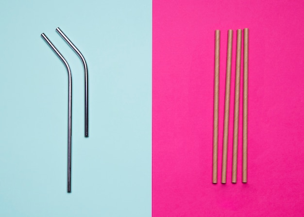 Metallic and paper straws on bicolored background