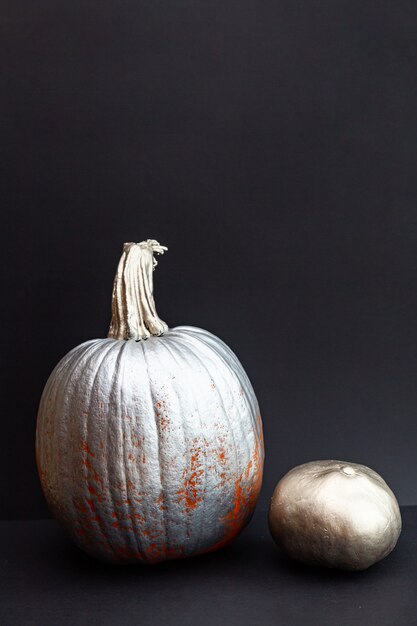 Photo metallic pumpkins on a black table.