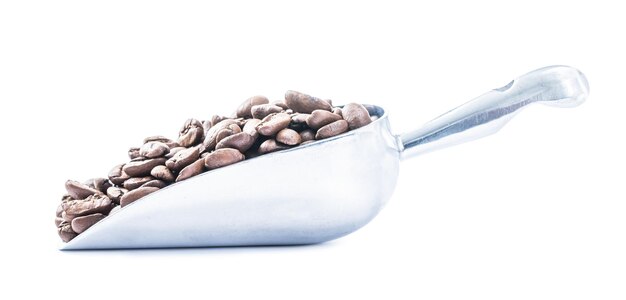 Metallic scoop with beans of coffee isolated on white