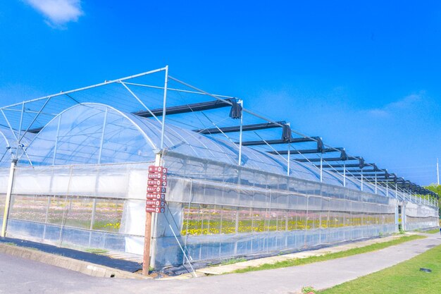 Metallic structure on field against blue sky