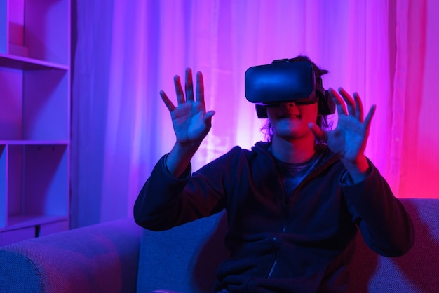 Metaverse technologieconcept Man draagt een VR-bril en heeft plezier bij het spelen van games in de virtuele wereld