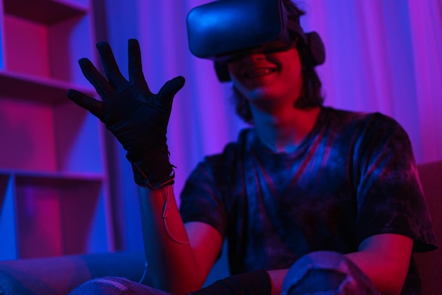 메타버스 기술 개념 남자는 게임을 하는 동안 제스처를 만들기 위해 VR 고글과 장갑을 착용합니다.
