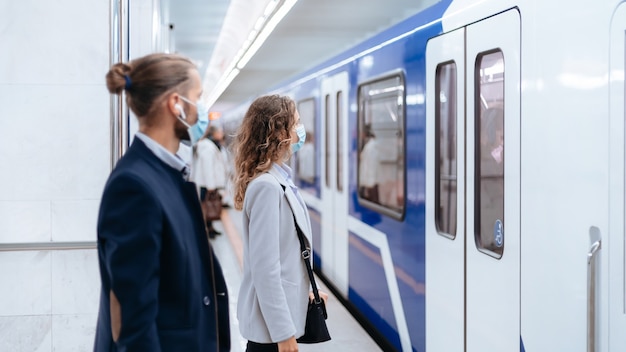 Metro passengers standing at a safe distance on the platform