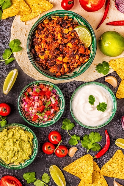 Mexicaans eten concept: tortilla's, nacho's met guacamole, salsa, chili con carne, bovenaanzicht.