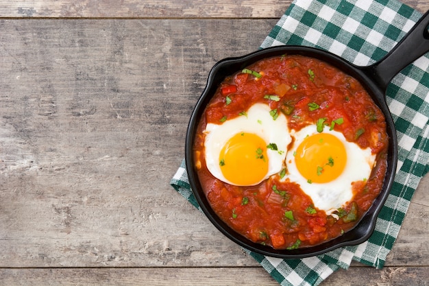 Mexicaans ontbijt, Huevos-rancheros in ijzerpan op de houten mening van de lijstbovenkant