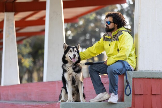 Mexicaanse afro kapsel man met zijn husky hond internationale hondendag