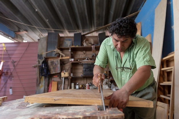 Mexicaanse houtbewerker, timmerman lakt in zijn atelier