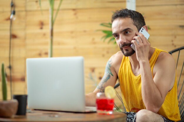 Mexicaanse jonge man bezig met zomervakantie bellen