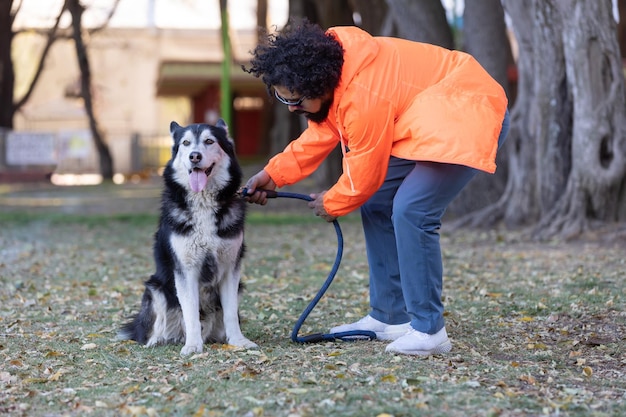 Foto mexicaanse man die zijn hond traint in het park.